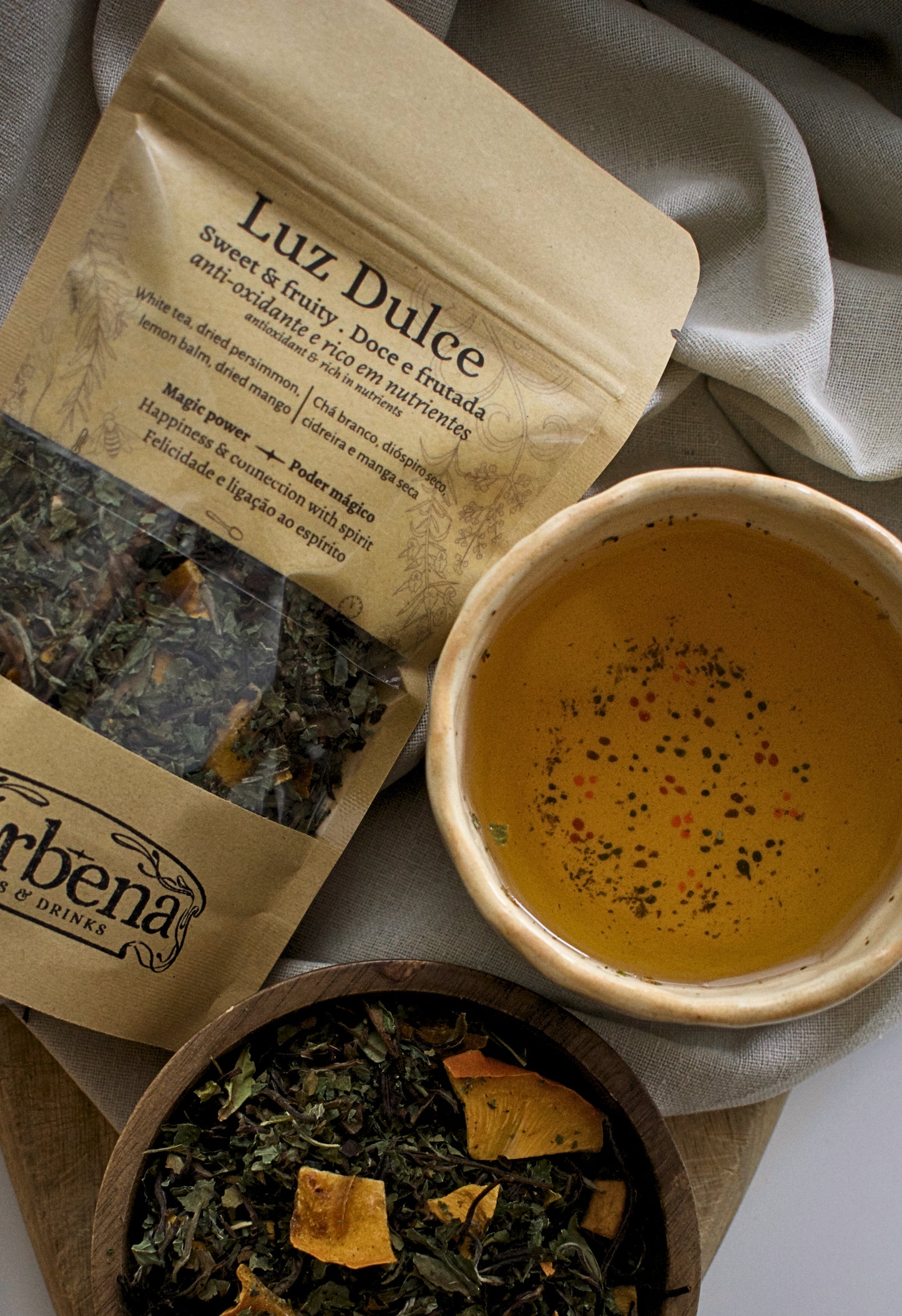 Tea packaging labeled 'Luz Dulce' with a bowl of tea and loose tea leaves on a neutral background.