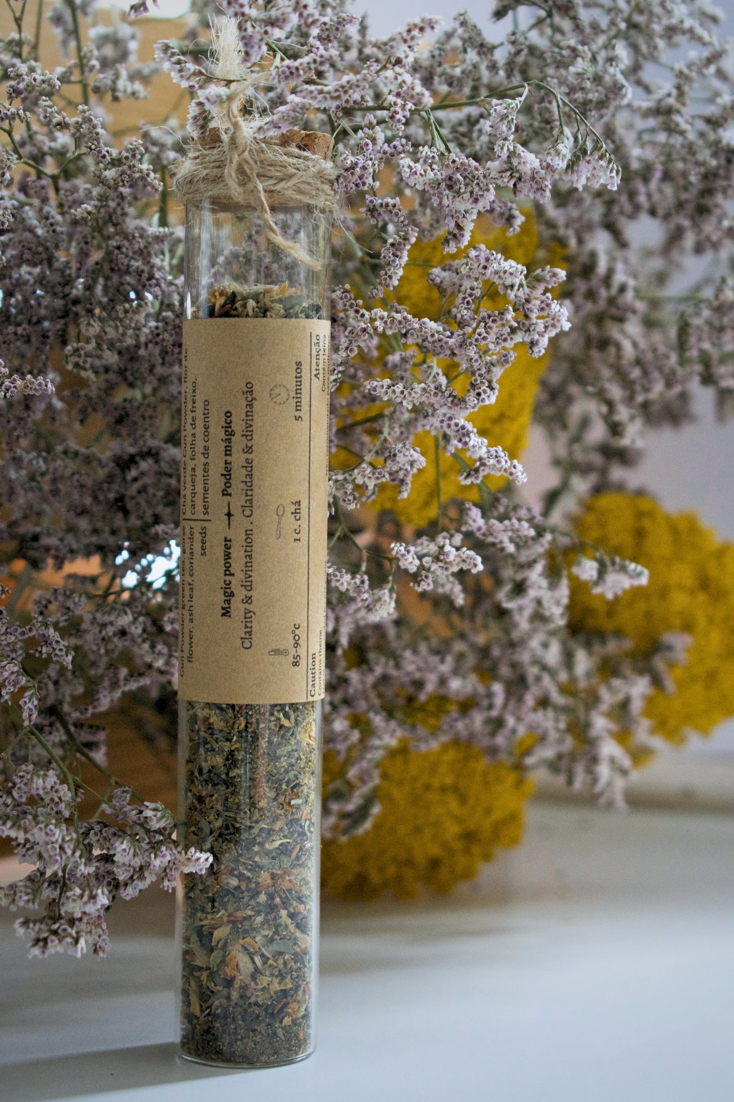 Cleanse tea blend in a glass tube on a floral background.