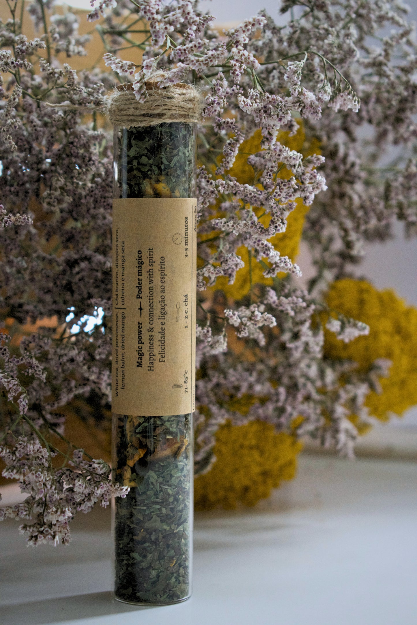 Luz Dulce in a glass tube on a floral background.