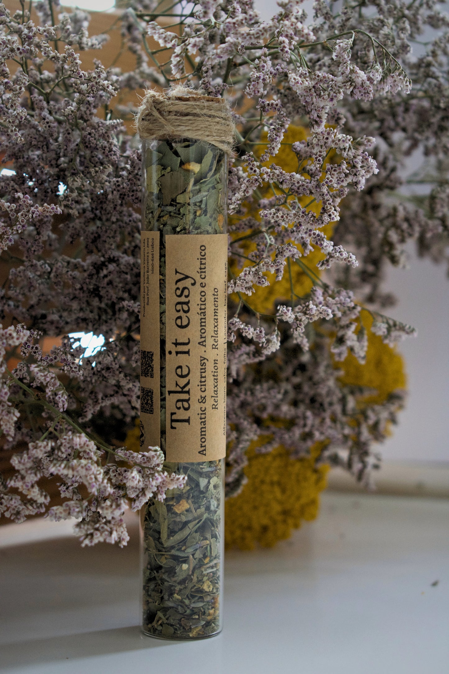 Glass tube with a label "take it easy" against a floral background.