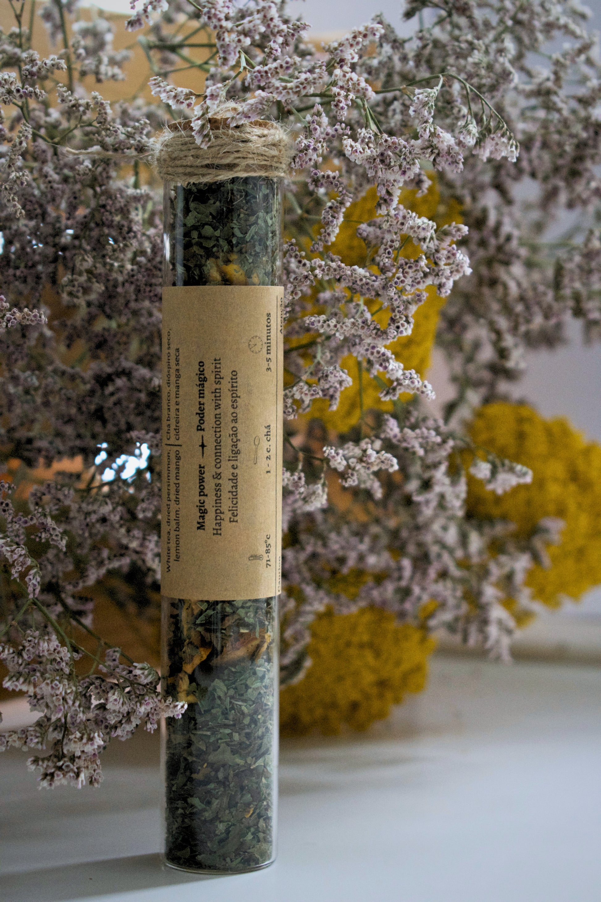 Luz Dulce in a glass tube on a floral background.