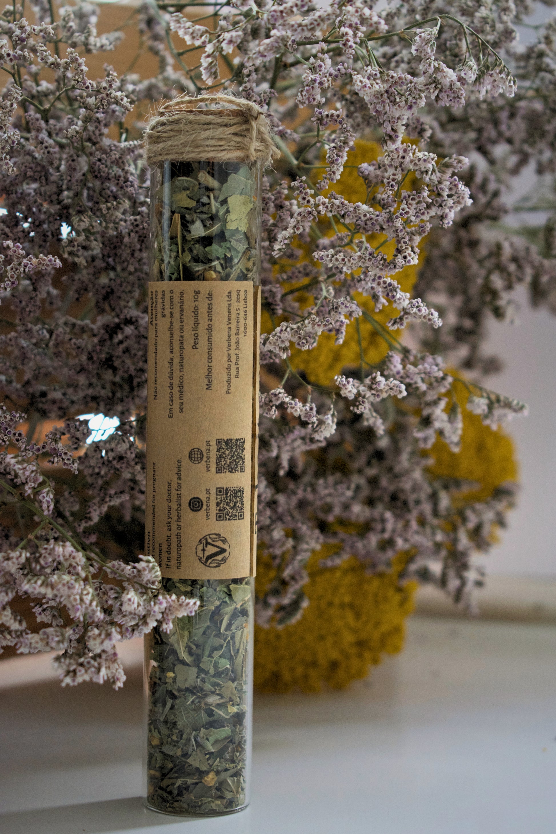 Glass tube with a label "take it easy" against a floral background.