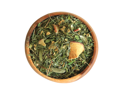 A wooden bowl filled with Mind Tonic loose leaves tea and dried apple.