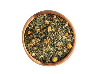 Wooden bowl filled with dried herbs and flowers on a white background